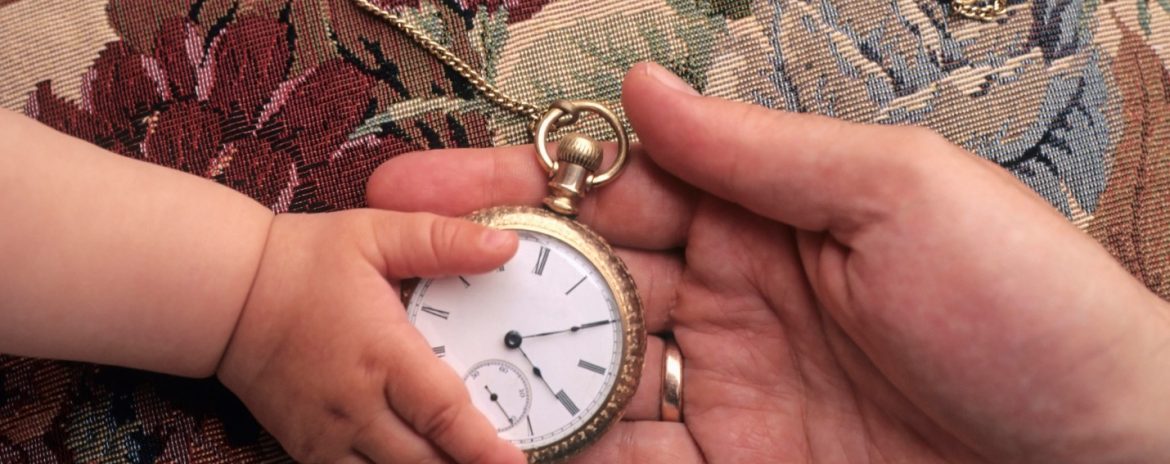 Father giving his child an antique pocket watch