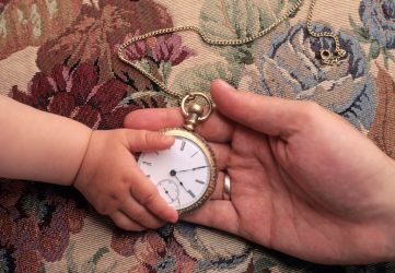 Father giving his child an antique pocket watch